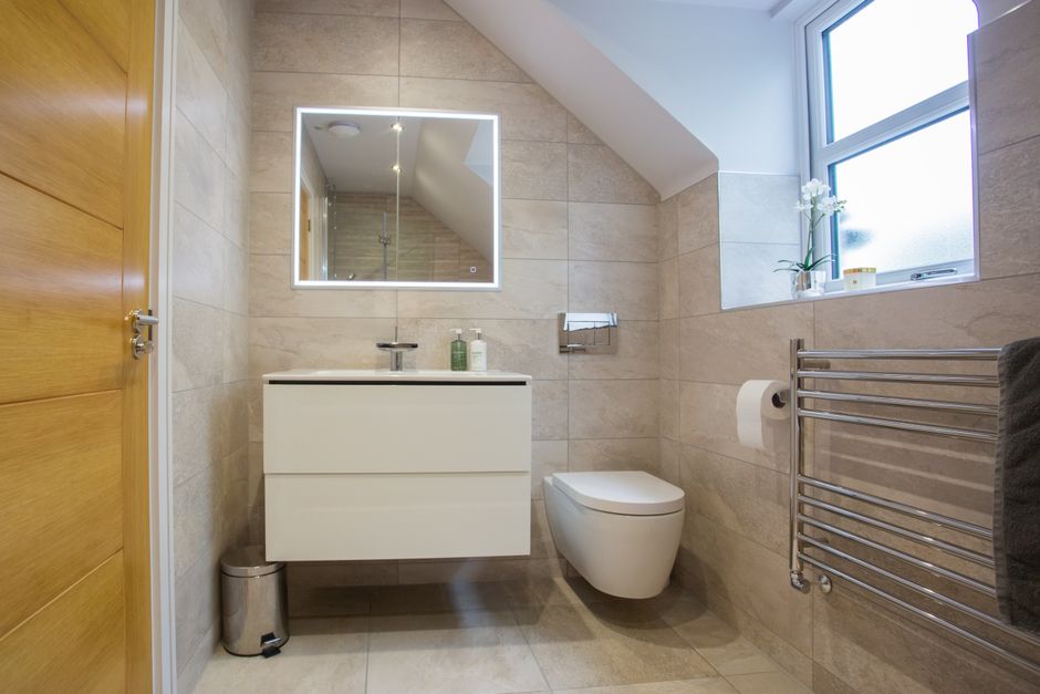 Finished luxury bathroom renovation with large-format porcelain tiles, wall-hung sanitaryware and walk-in shower, showing typical high-end bathroom renovation cost specification